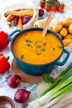 Pot of hearty potato soup with fresh vegetables
