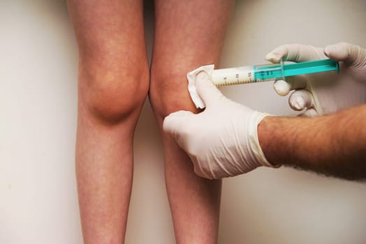 Doctor gives a child an injection in the leg