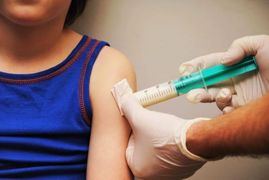 Doctor gives an injection to a little boy