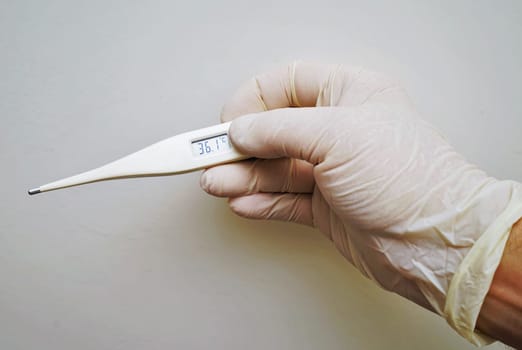 Doctor hold medical digital thermometer in hand on white background