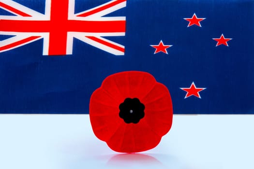 A remembrance day poppy flower with a Australian Flag on the background.