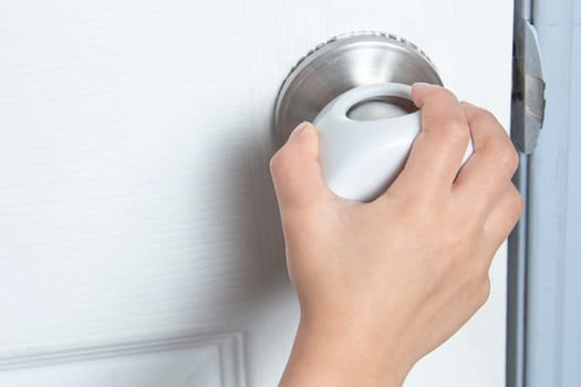 A kid trying to open the door with a child Proof Door Knob Covers over doorknob.