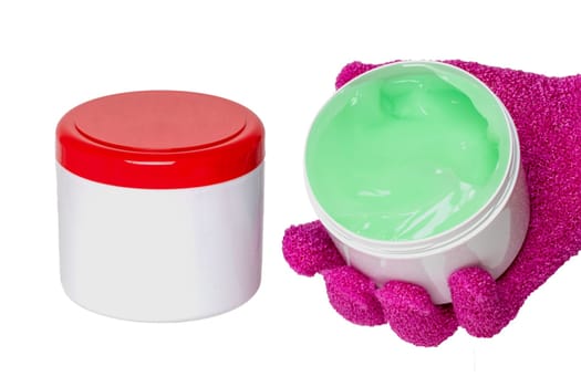 Close-up of a closed and an open container with cooling gel (horse balm) for sports injuries isolated on a white background. The open container is held by a pink massage glove. Copy space. Macro.
