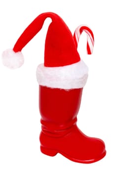 Christmas decorations isolated. Close-up of a red Santa Claus boot with a santa claus hat and a traditional striped candy canes on it isolated on a white background. Beautiful xmas design element.