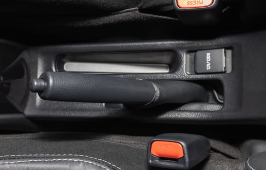 Gray Hand Brake and Seatbelt Lock Inside Car on Center Frame