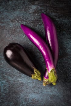 Assortment of fresh aubergines on dark background