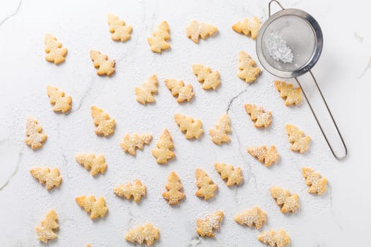 Homemade Christmas cookies in Christmas tree shape on marble background