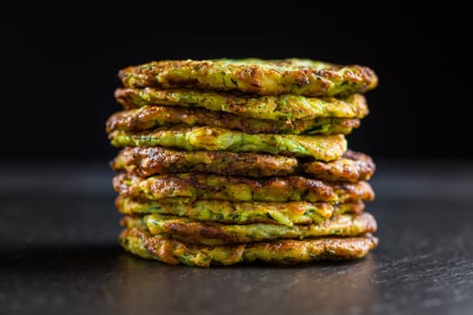 Zucchini pancakes on black background