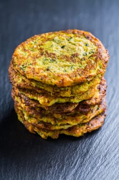 Zucchini pancakes on black background