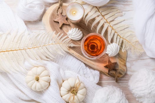 Cosy still life for winter and autumn with glass of pink wine, pumpkin cookie, wool and warm sweater