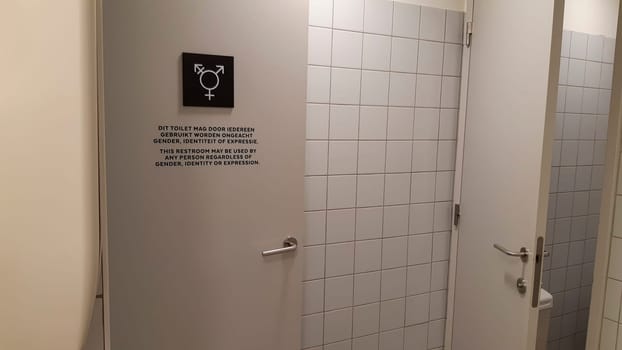 Antwerp, Belgium, May 2020: Gender neutral toilet symbol and sign on a door, in Dutch and English language