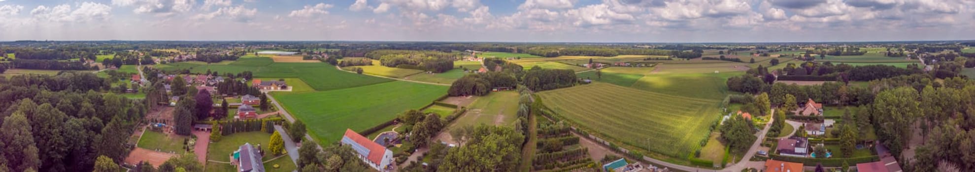 Itegem, Belgium, July 2020: Aerial panorama view on a countryside area in Belgium Kempen area with houses and agricultural fields