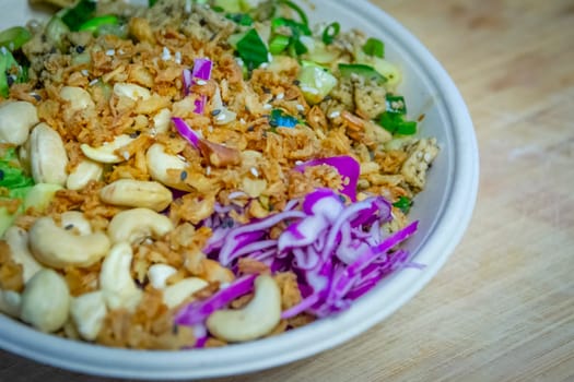 Vegan poke bowl with cashew nuts, red cabbage, dried onions, avocado and much more ingredients. Healty food. Ready to eat.