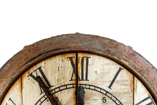 Old vintage and retro analogue clock displaying five minutes to twelve. Worn-out and grunge style with wooden background. Front view.