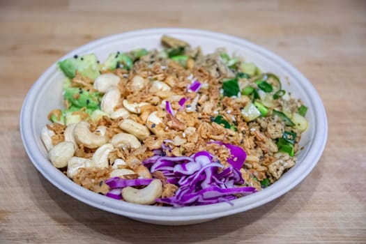 Vegan poke bowl with cashew nuts, red cabbage, dried onions, avocado and much more ingredients. Healty food. Ready to eat.