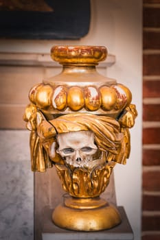 Skull ceremonial urn, worn and broken, on pedestal in The Cathedral Basilica of St James the Apostle in Szczecin, Poland