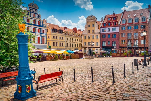 Traditional blue water pump with gryphon head crest from Stettin city emblem and old town square in background. Gryphon is Stettin emblem since 1360