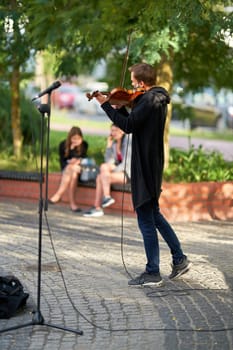 Street musician with violin on the beach promenade of Swinoujscie in Poland