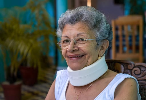 Smiling elderly woman wearing homemade looking cervical immobilizer collar