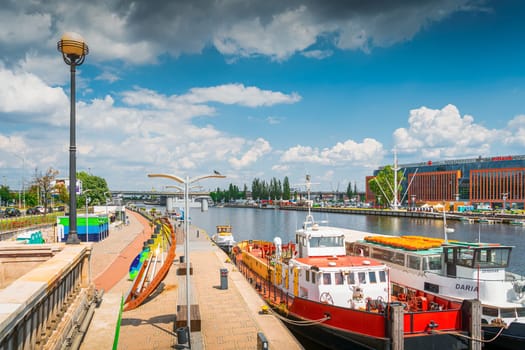 Boats docked on Wieleckie Quay, view from Long Bridge, called Most Dlugi in Szczecin, Poland. Promenade and boulevards on Odra River embarkment