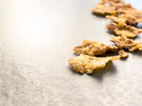 A group of corn flakes on a gray floor. Daily breakfast and nutrition