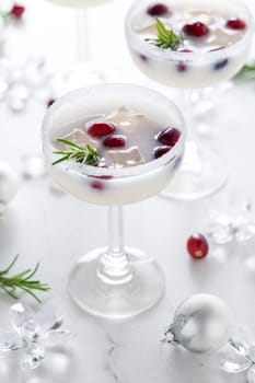 White Christmas margarita punch with cranberries and rosemary on marble background