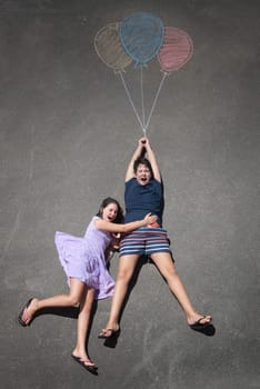 Young kids playing with chalk drawn balloons