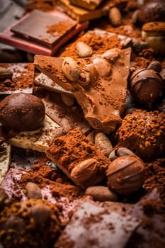 Variation of chocolate and chocolate candy with cocoa and cocoa beans as background