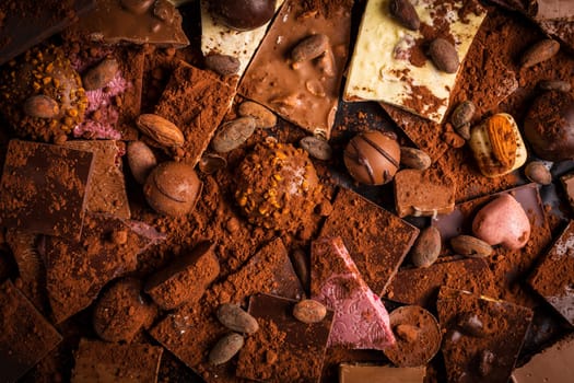 Variation of chocolate and chocolate candy with cocoa and cocoa beans as background