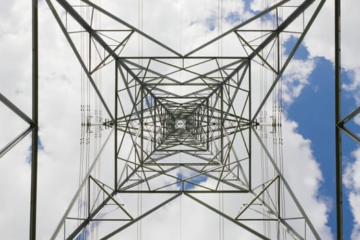 Abstract hard texture from this industrial themed image of an electrical pylon transmission tower. Looking to the sky as the metal converges.