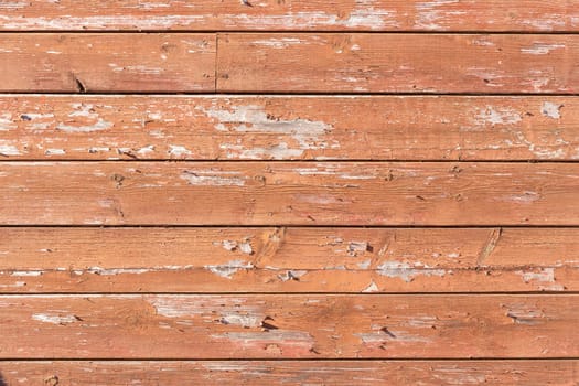 Texture of red paint peeling off boards