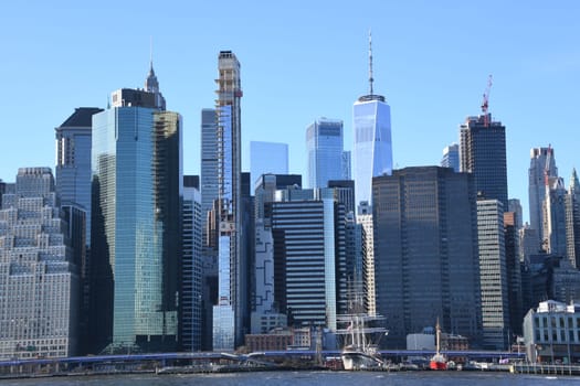 The skyline of the Financial District in Lower Manhattan seen from Brooklyn. In the foreground the East River.