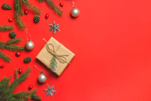 Christmas composition. Frame made of christmas gifts, pine branches, isolated on red background. Flat lay, top view.