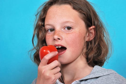 Girl eating a tomato