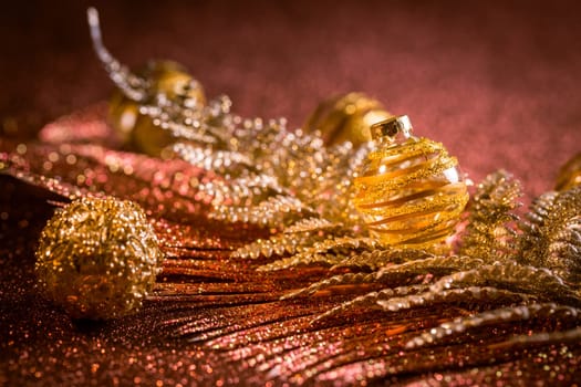 Christmas balls and ornaments with glitter background in red and golden tones. Selective focus.