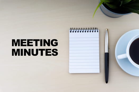 MEETING MINUTES text with fountain pen, notepad, and decorative flower on wooden background. Business and copy space concept..