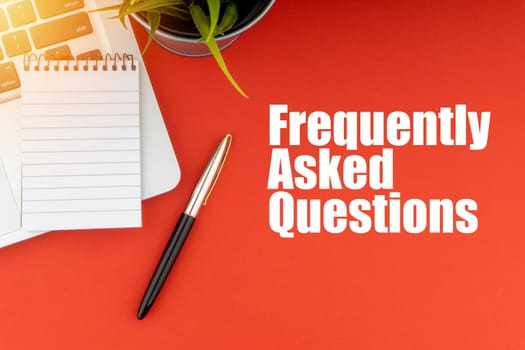 FREQUENTLY ASK QUESTIONS or FAQ text with notepad, laptop, fountain pen and decorative plant on red background. Business and Copy Space Concept