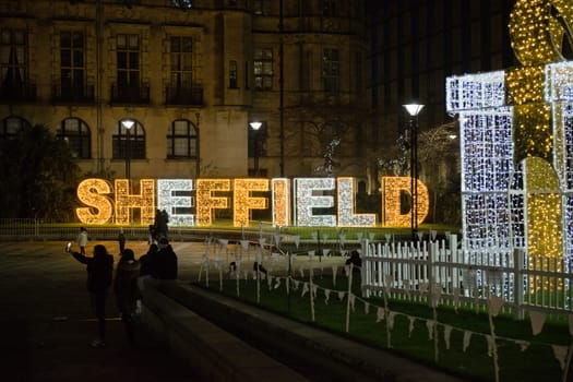 Sheffield, United Kingdom, 27th November, 2020: City center christmas light display in the peace gardens area. People taking photos with the lit gift