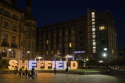 Sheffield, United Kingdom, 27th November, 2020: People taking photos with and enjoying the illuminated sheffield city center christmas lights of 2020