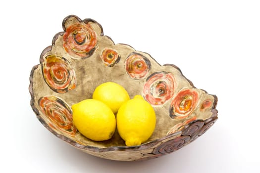 fresh lemons in a clay bowl - white background