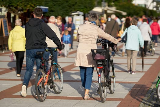 Tourists with bicycles on the popular beach promenade of Swinoujscie in Poland