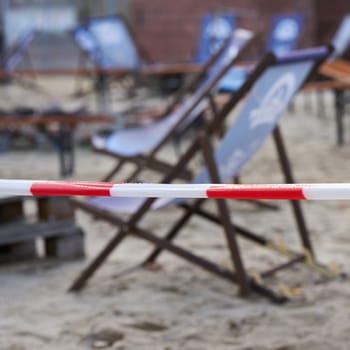 Barrier of a closed beach bar with barrier tape during the Corona pandemic in Germany