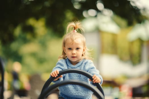 blonde haired girl on a swing