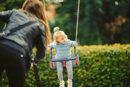 blonde haired girl on the swing