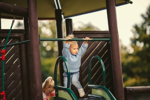 blonde haired girl on the slide
