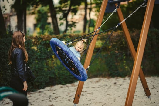 blonde haired girl on the swing