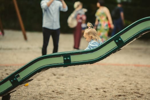 blonde haired girl on the slide