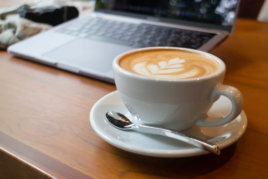 Cup of coffee and laptop on the table, stock photo