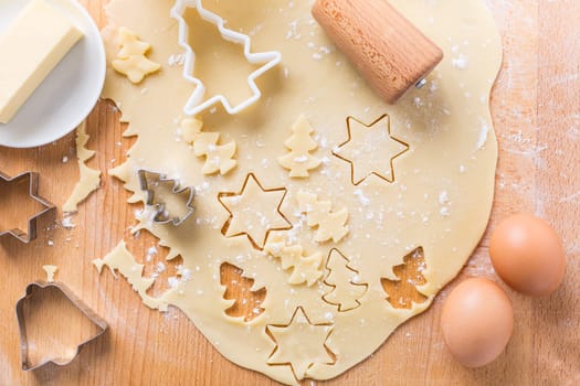 Christmas baking - dough with cookie cutter and baking ingredients. Homemade bakery, xmas sweet, winter holidays concept.