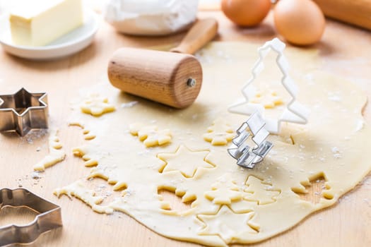 Christmas baking - dough with cookie cutter and baking ingredients. Homemade bakery, xmas sweet, winter holidays concept.